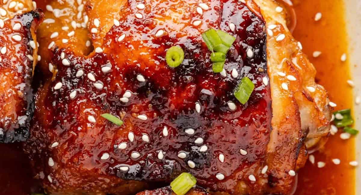 Up close image of baked honey soy chicken thighs with garnish. 