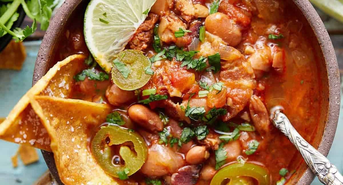 Overhead image of instant pot charro beans with garnish. 