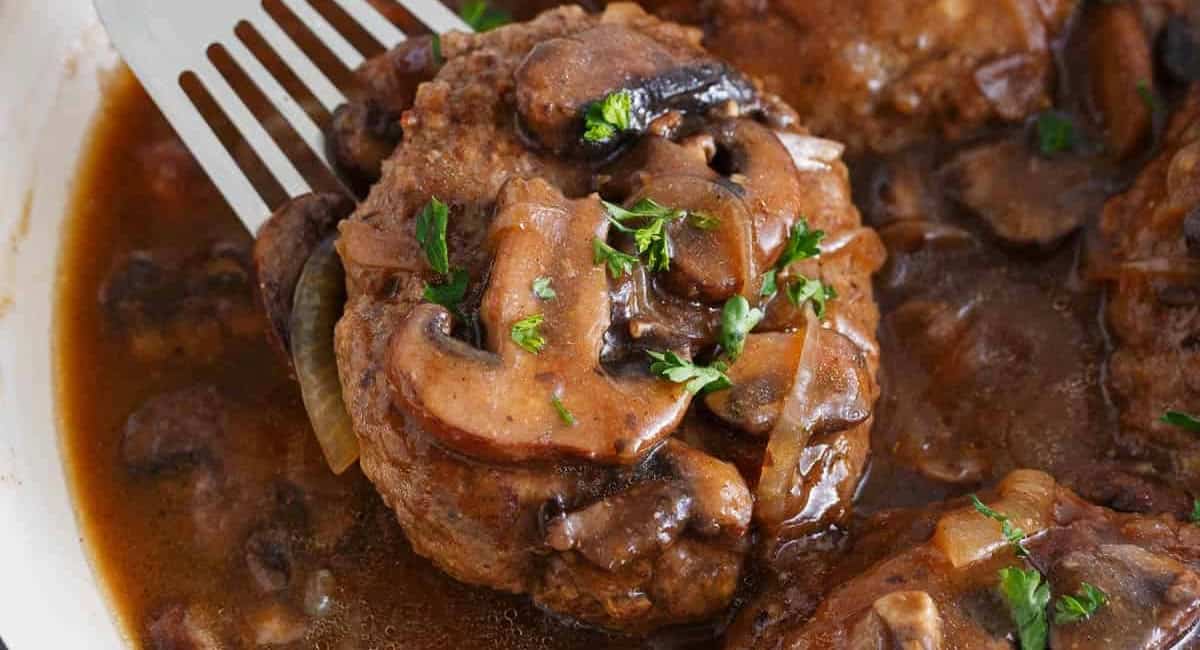 UP close image of salisbury steak recipe with garnish. 