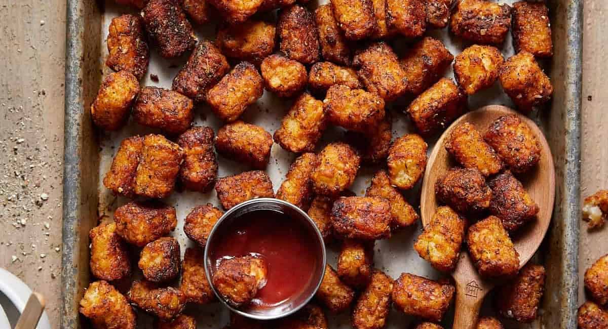 Overhead image of seasoned tater tots with ketchup dip.