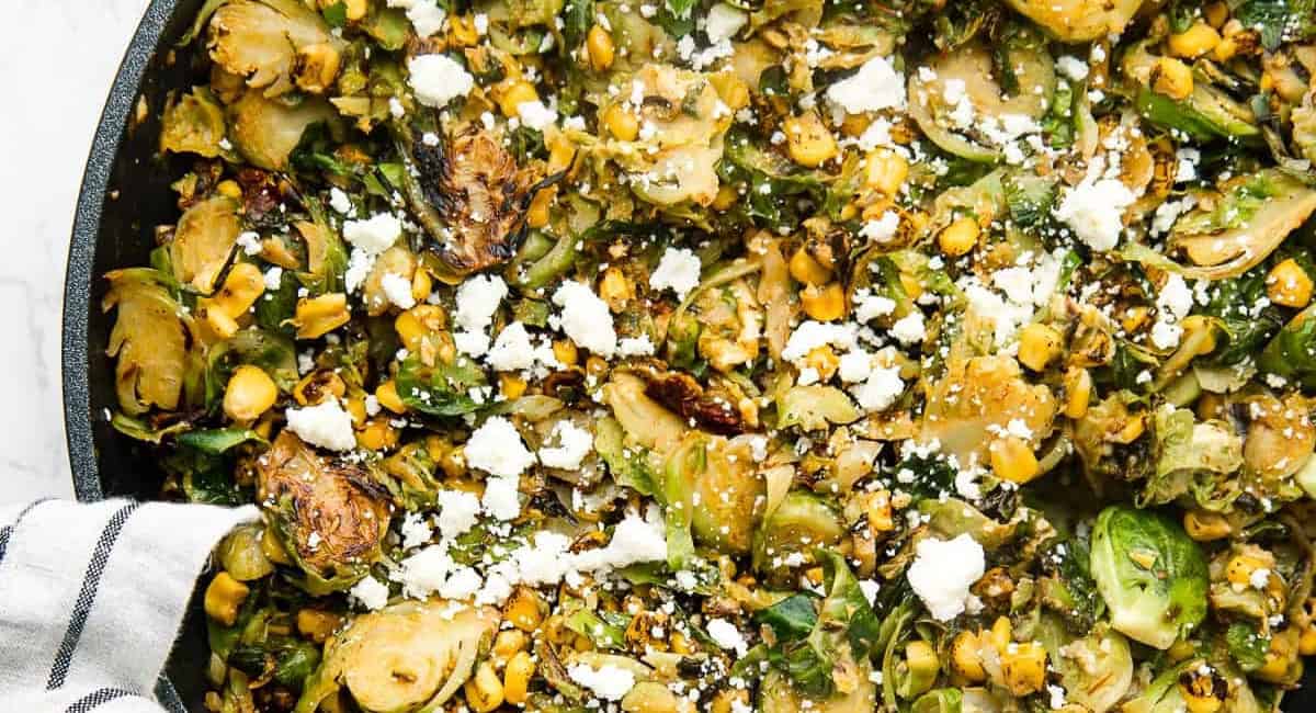 Overhead image of Mexican chipotle brussel sprouts with garnish. 