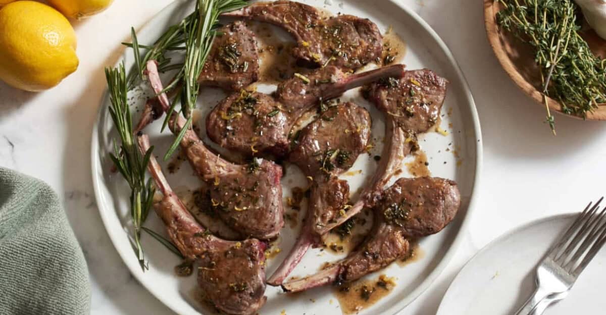 Overhead image of pan seared lamb chops with rosemary garnish. 