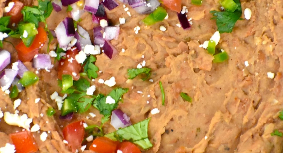 Overhead image of refried beans with garnish. 