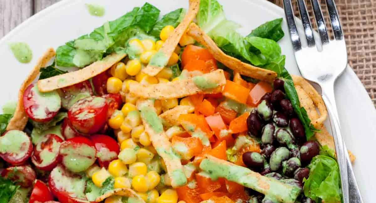 Overhead image of southwest chopped salad on white dish with fork. 