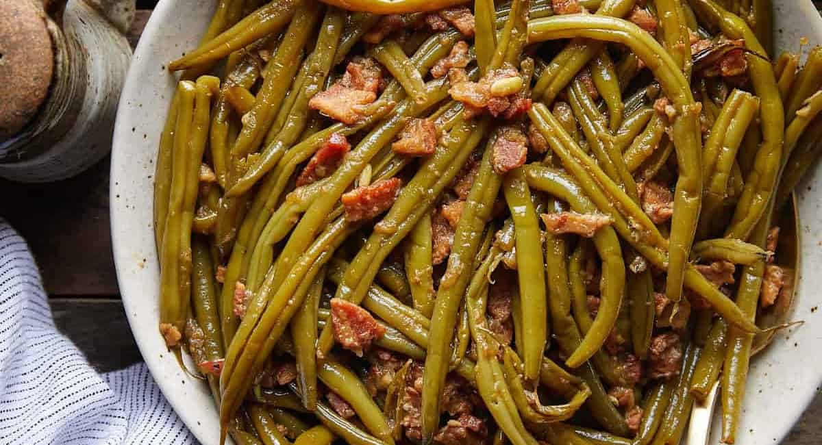 Overhead image of crockpot green beans in white dish. 