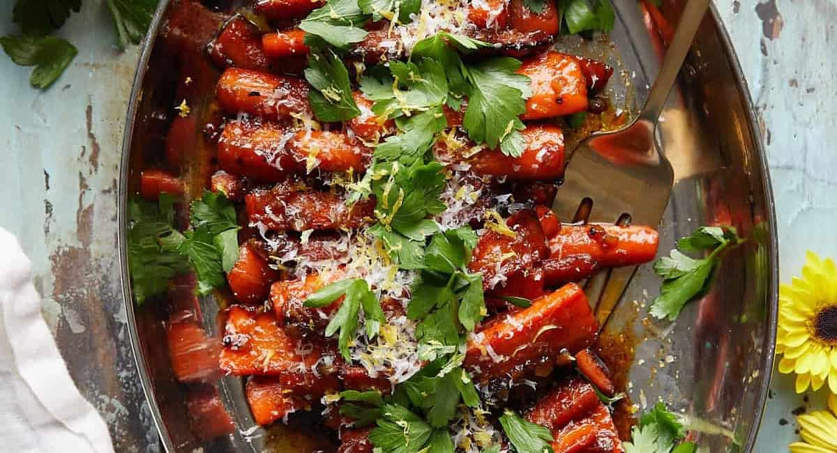 Overhead image of glazed stovetop carrots with garnish. 