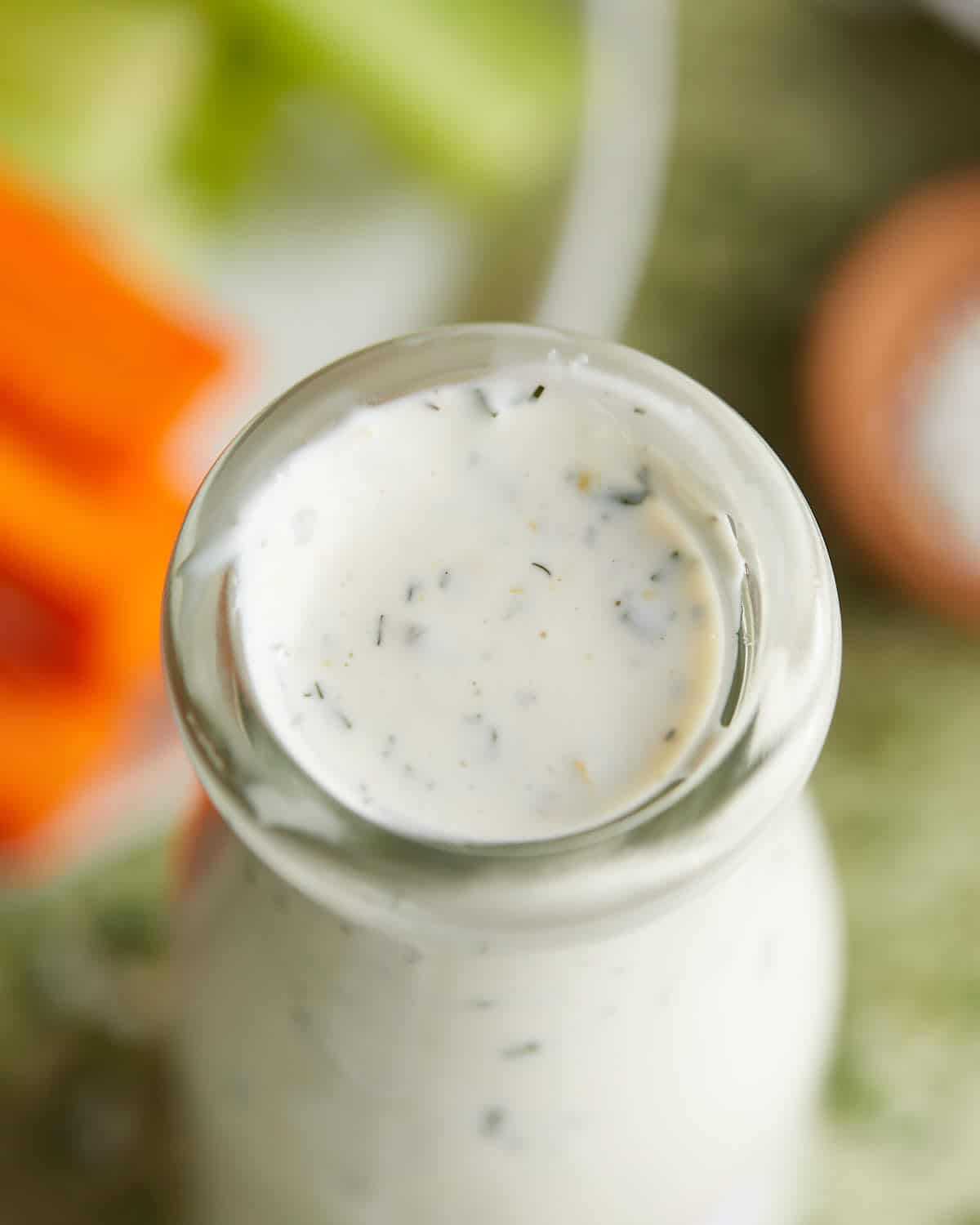 Overhead image of homemade greek yogurt ranch dressing in a glass jar. 