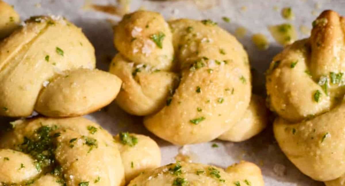 Up close image of sourdough discard garlic knots with garnish. 