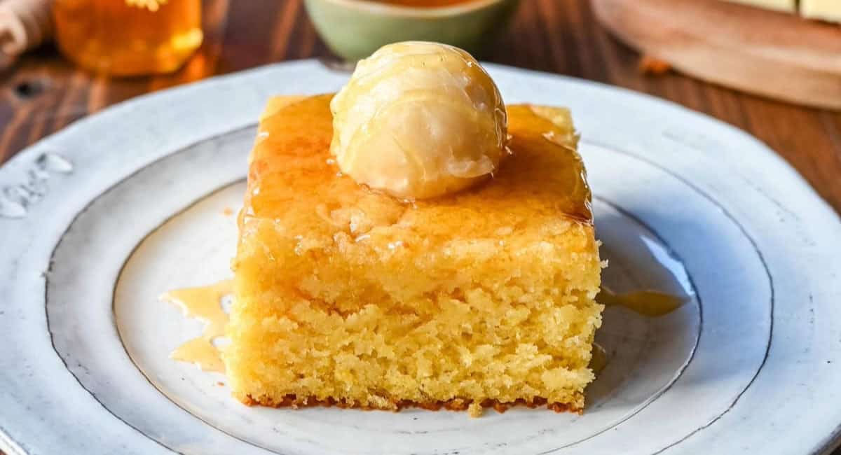 Up close image of cornbread recipe with butter topping and honey. 