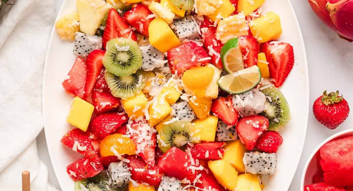 Overhead image of a tropical fruit salad with garnish. 