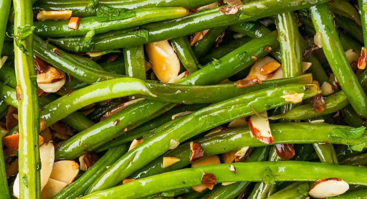 Overhead close up photo of green beans almondine. 
