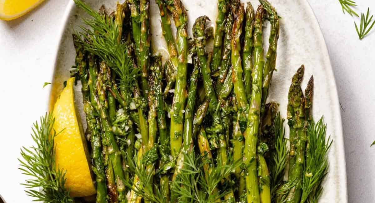 Overhead image of lemon herb roasted asparagus with garnish. 