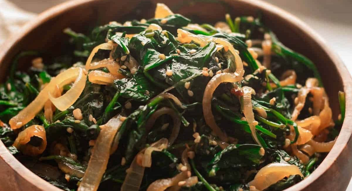 Overhead image of sautéed spinach with garlic and onions. 