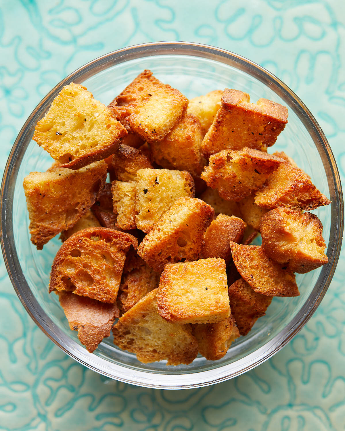 Overhead image of air fryer croutons in clear bowl. 