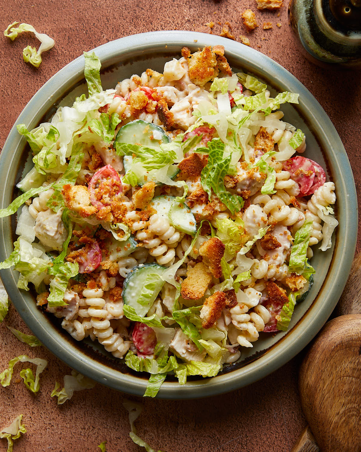 Overhead image of chicken caesar pasta salad in blue dish. 