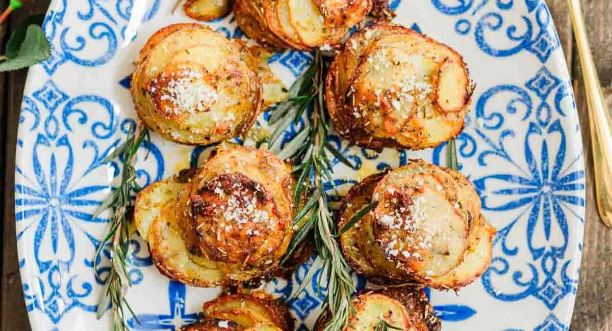 Overhead image of chipotle herbs muffin tin potatoes on white and blue dish with garnish. 