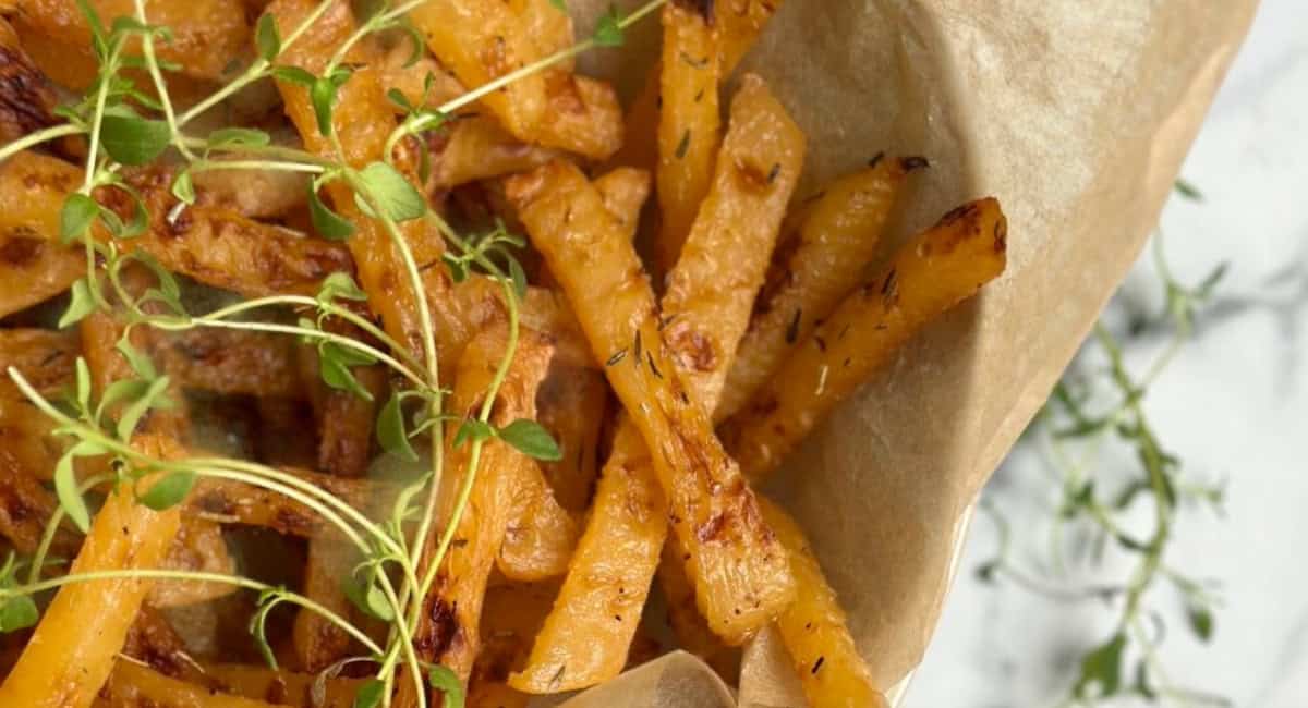 Overhead image of oven roasted rutabaga fries with garnish. 