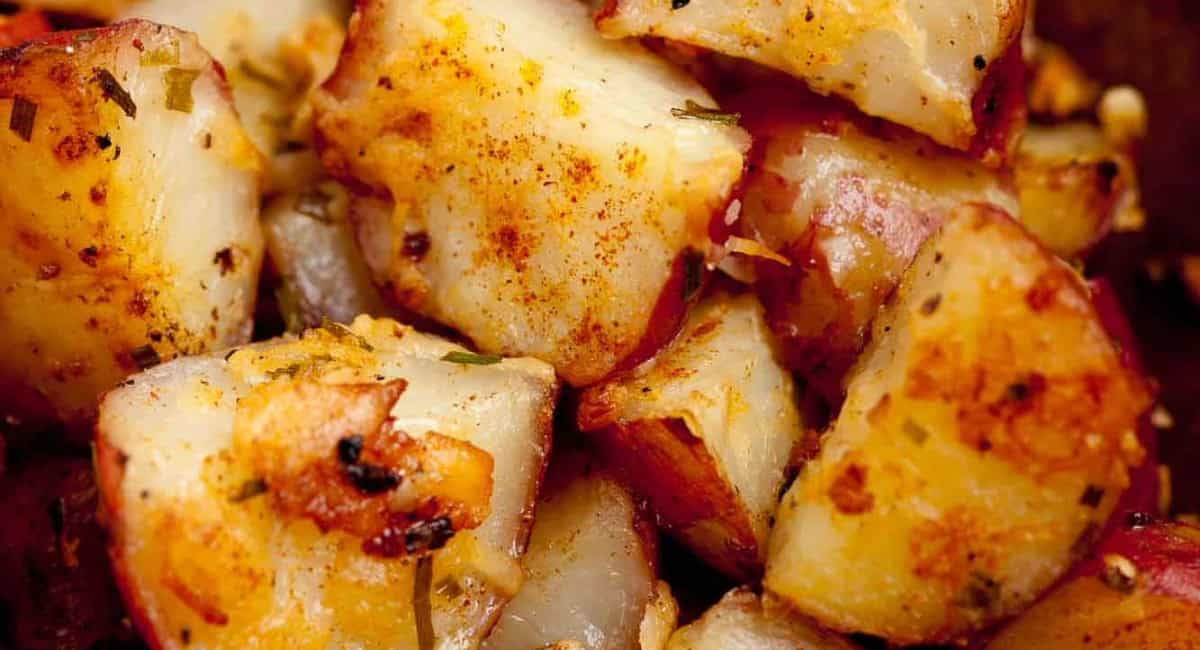 Overhead up close image of roasted red potatoes with garnish. 