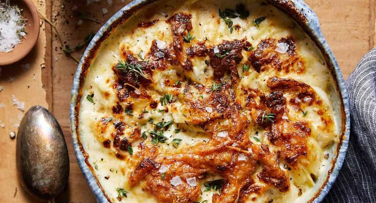 Overhead image of air fryer scalloped potatoes in blue bowl. 