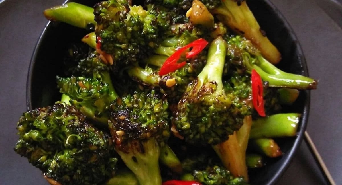 Overhead image of Asian broccoli stir fry in black bowl. 
