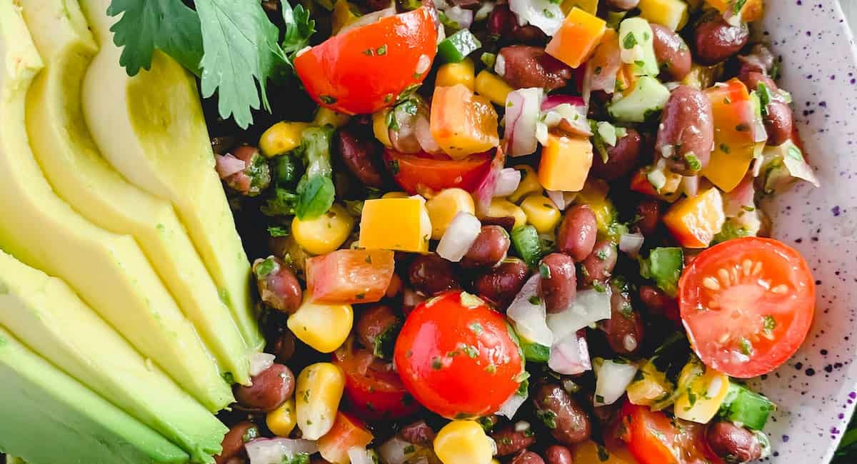 Overhead up close image of fiesta salad with avocado slices as garnish. 