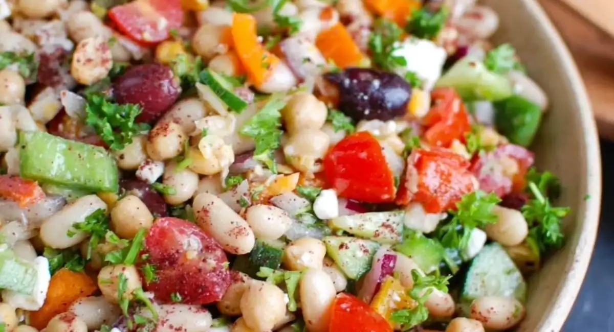 Up close overhead image of Mediterranean bean salad with garnish. 