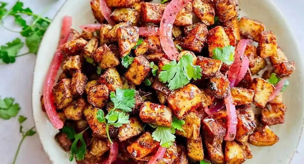 Overhead image of roasted Mexican potatoes with garnish. 