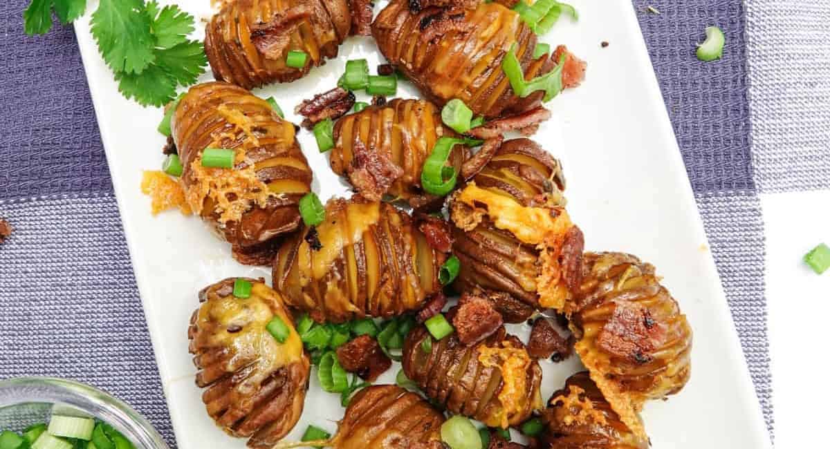 Overhead image of smoked hasselback potatoes on white platter. 