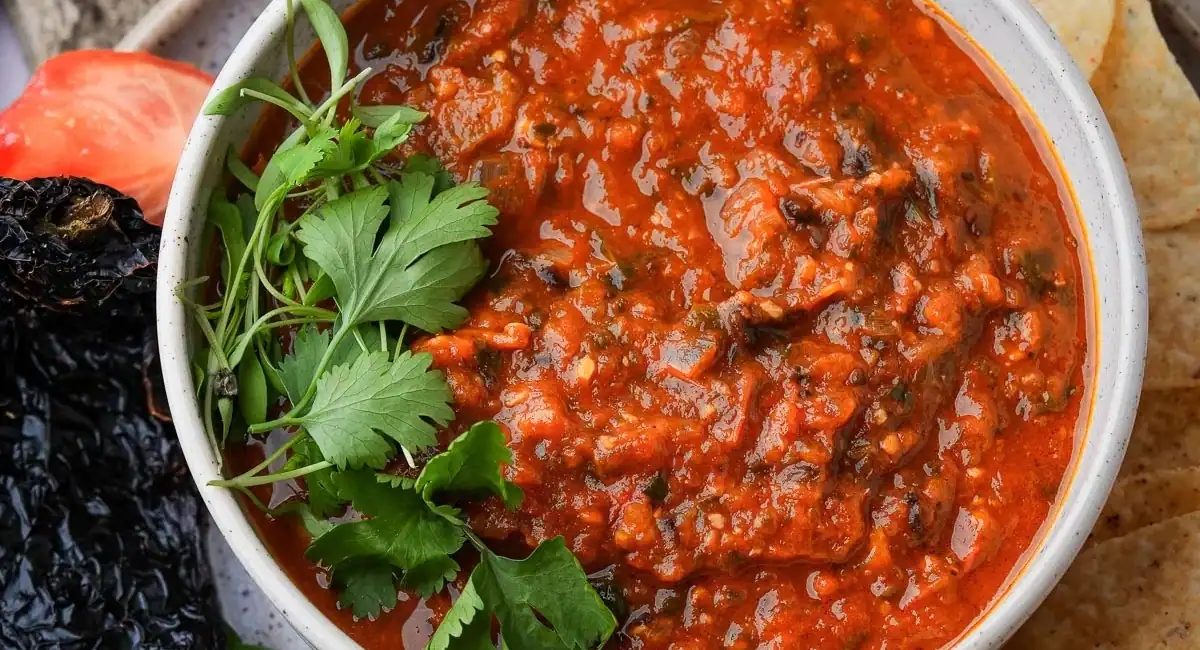 Overhead and up close image of salsa roja recipe with garnish. 