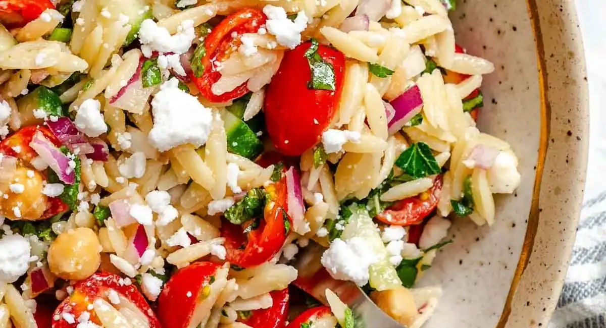 Overhead image of summer orzo pasta salad with garnish. 