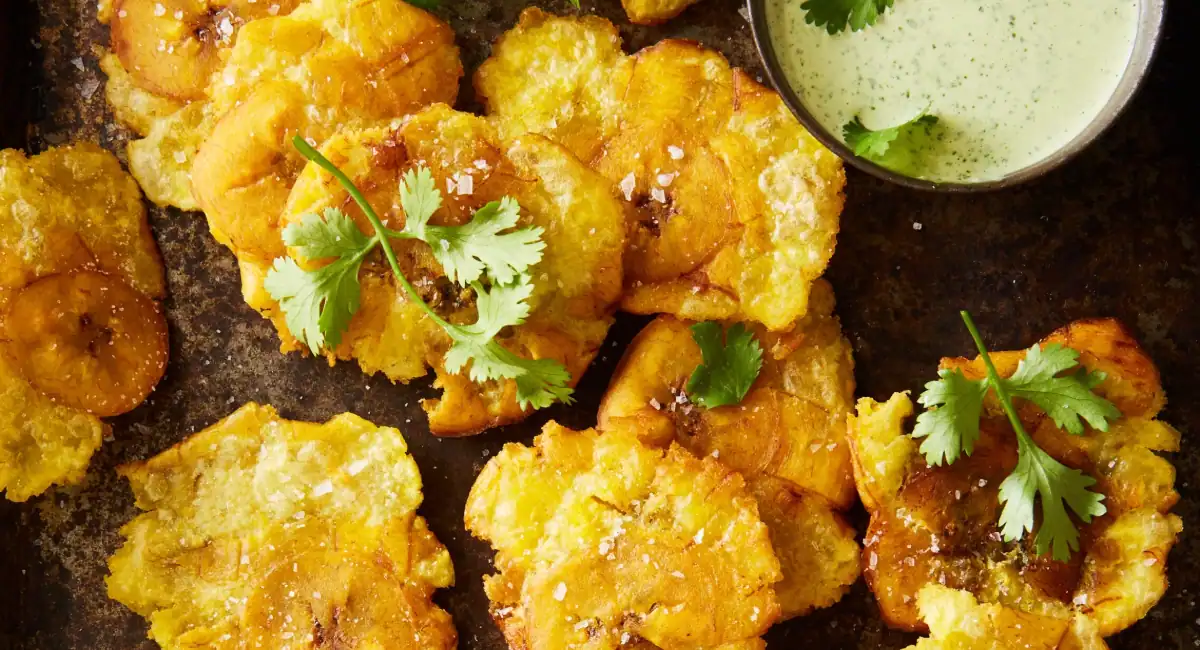 Overhead up close image of tostones with cilantro jalapeno green sauce. 