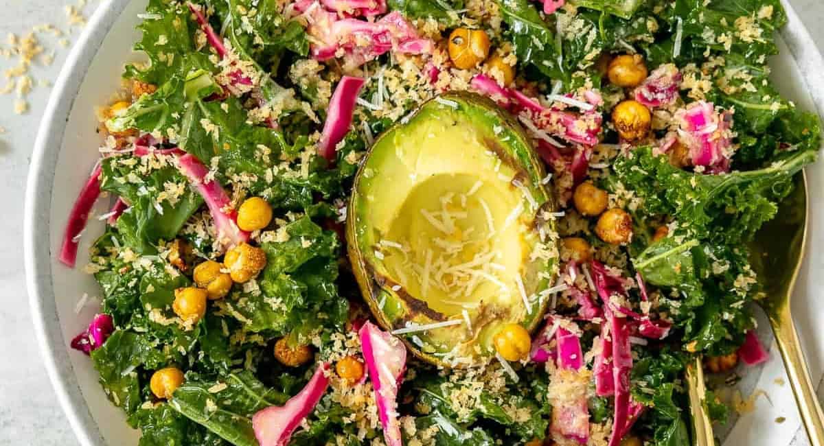 Overhead image of avocado kale salad with garnish. 