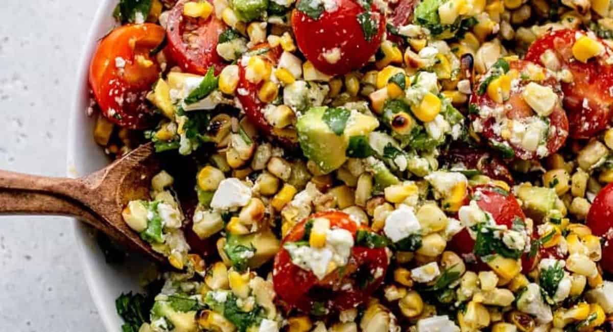 Overhead up close image of grilled corn avocado salad with cilantro lime dressing. 