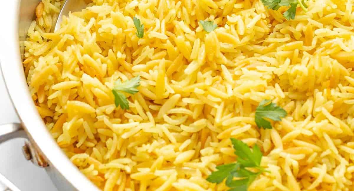 Overhead up close image of orzo rice pilaf with garlic and herbs. 
