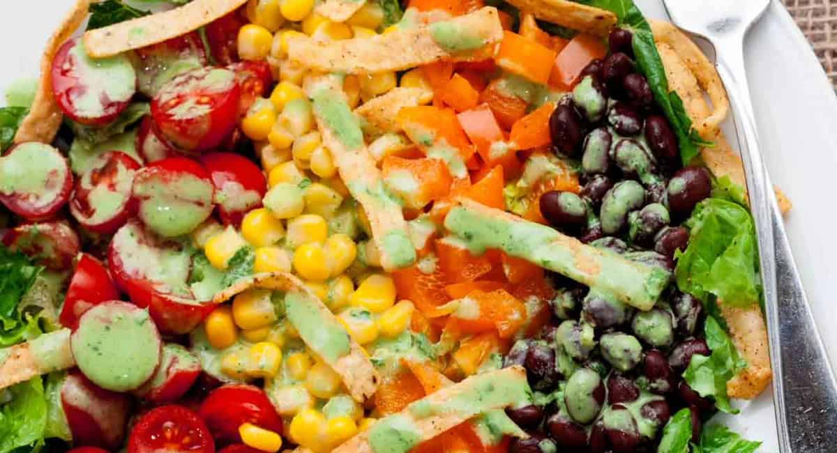 Overhead up close image of southwest chopped salad on white plate with fork. 