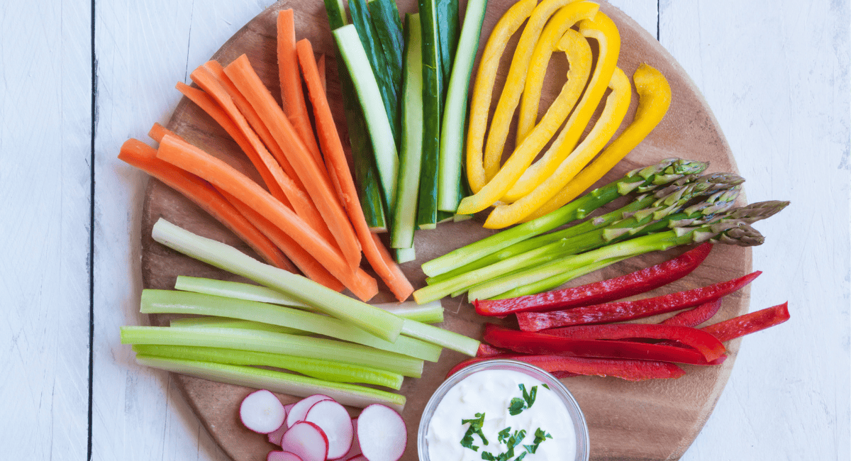 Overhead image of cut veggies and small dip. 
