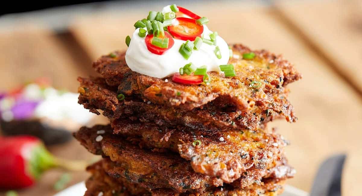 Up close image of bacon zucchini fritters with garnish. 