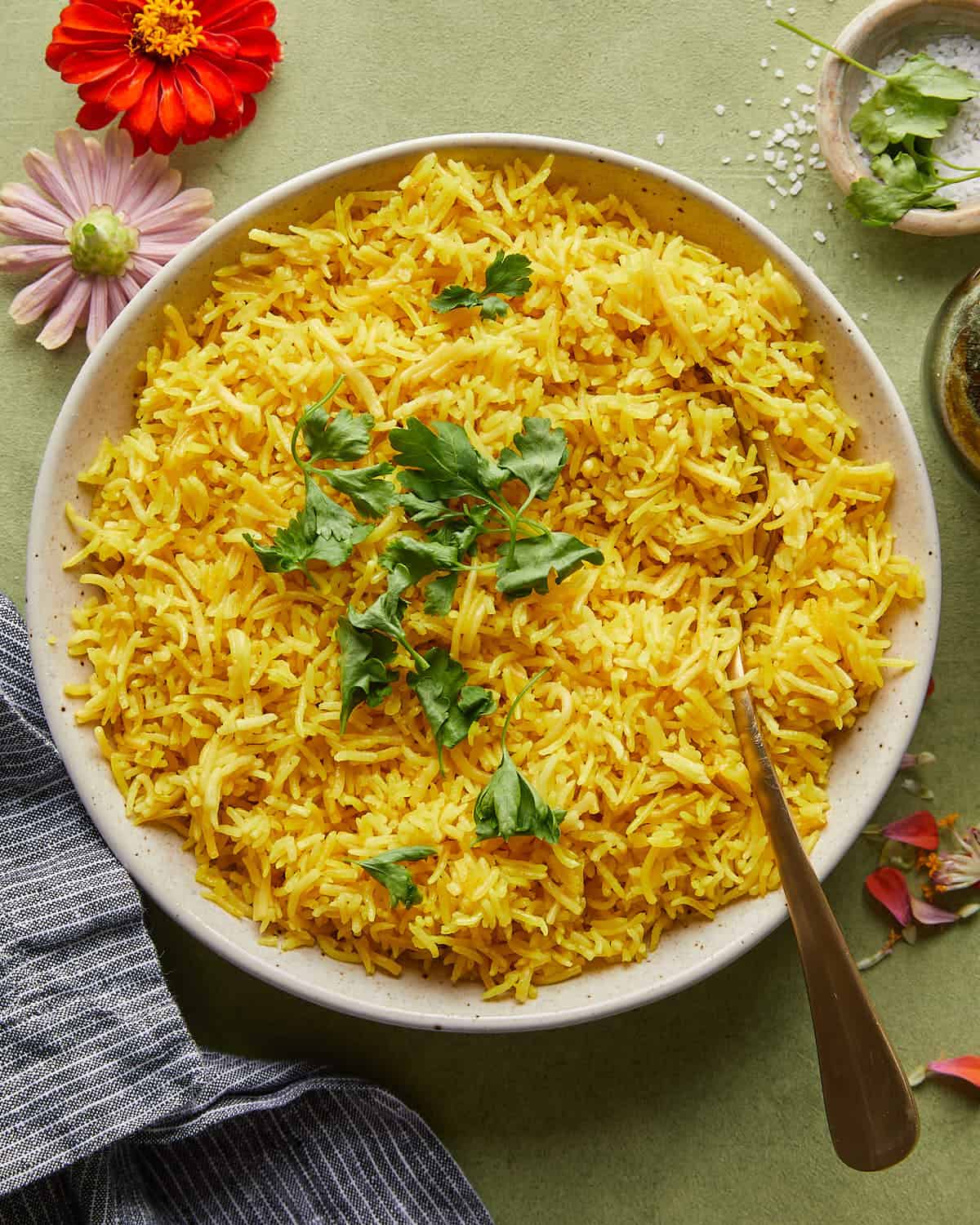 Overhead image of yellow rice recipe with garnish. 