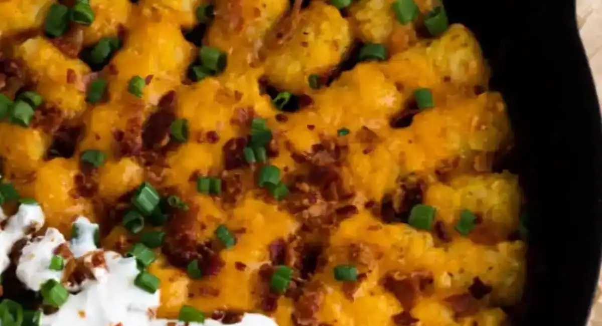 Overhead up close image of grilled loaded tater tots with garnish. 