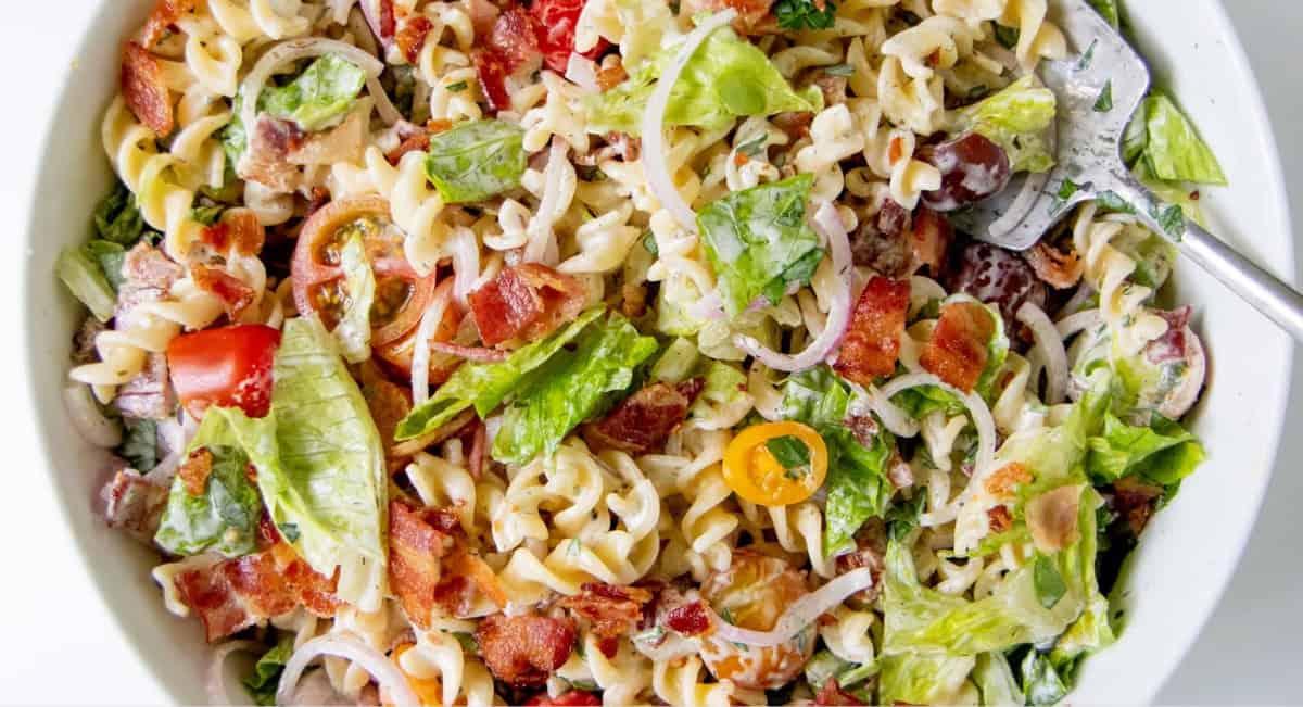 Overhead image of ranch BLT pasta salad in white bowl. 