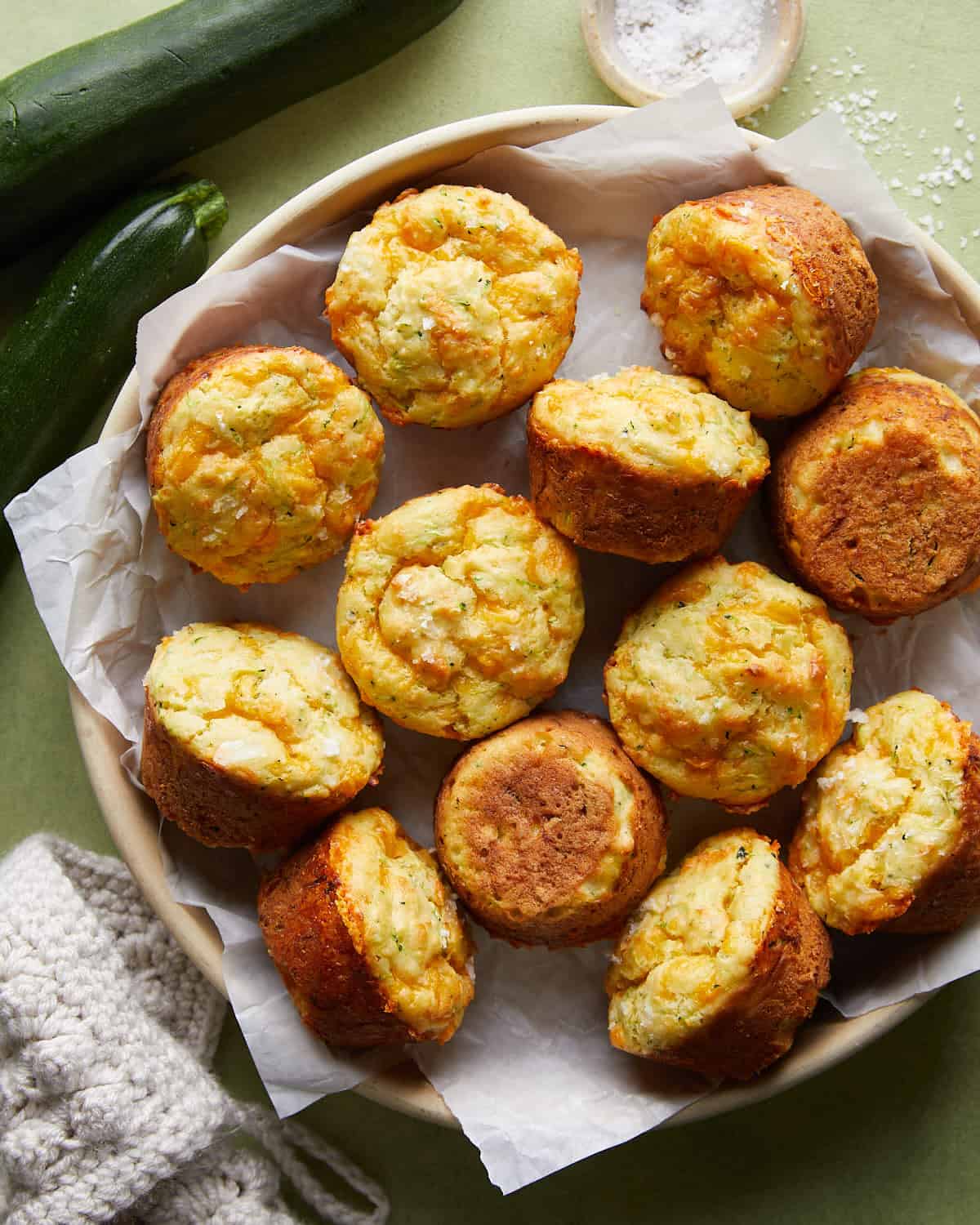 Overhead image of savory zucchini muffins on white dish.