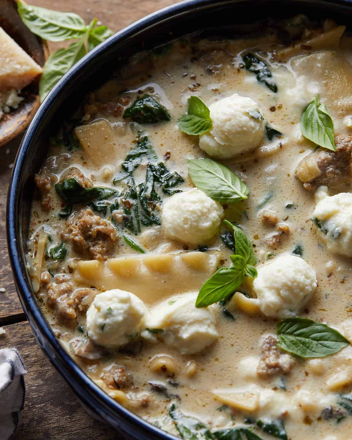 Up close overhead image of white lasagna soup with garnish. 