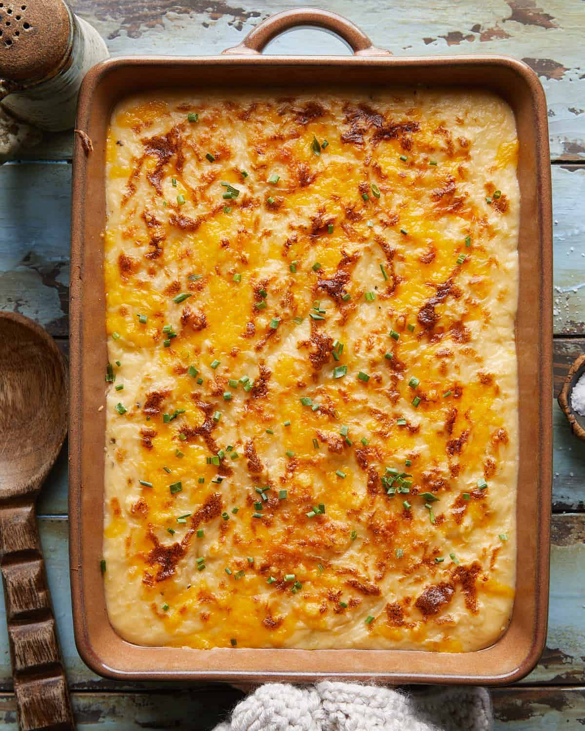 Overhead image of cheesy mashed potatoes with garnish.