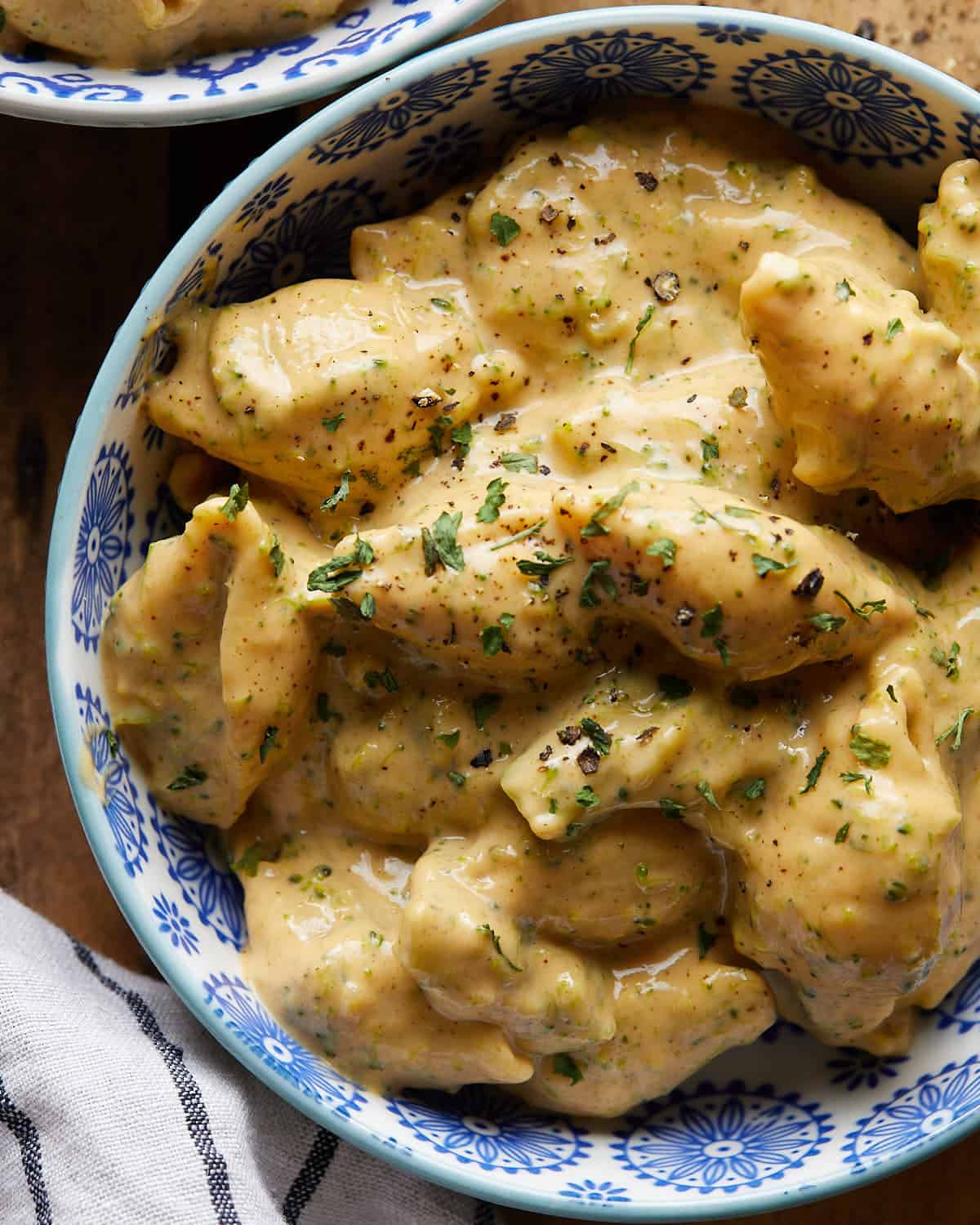 Up close image of broccoli mac and cheese in white and blue dish.