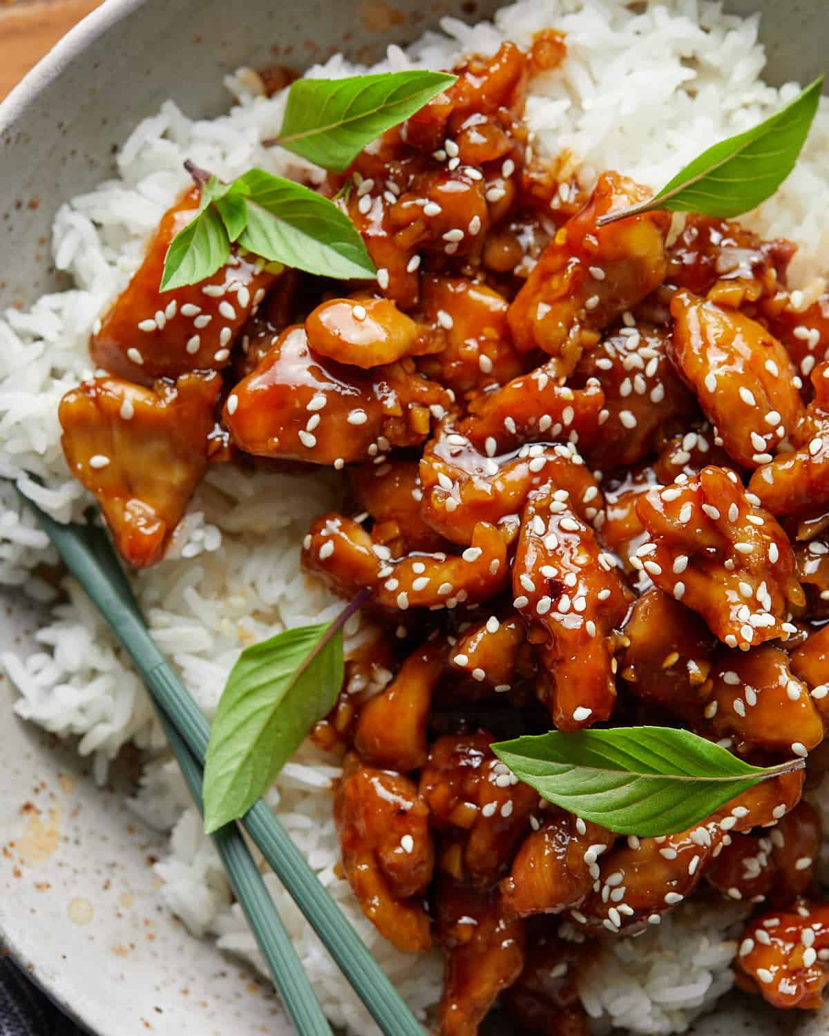 Up close overhead image of easy orange chicken recipe with garnish.
