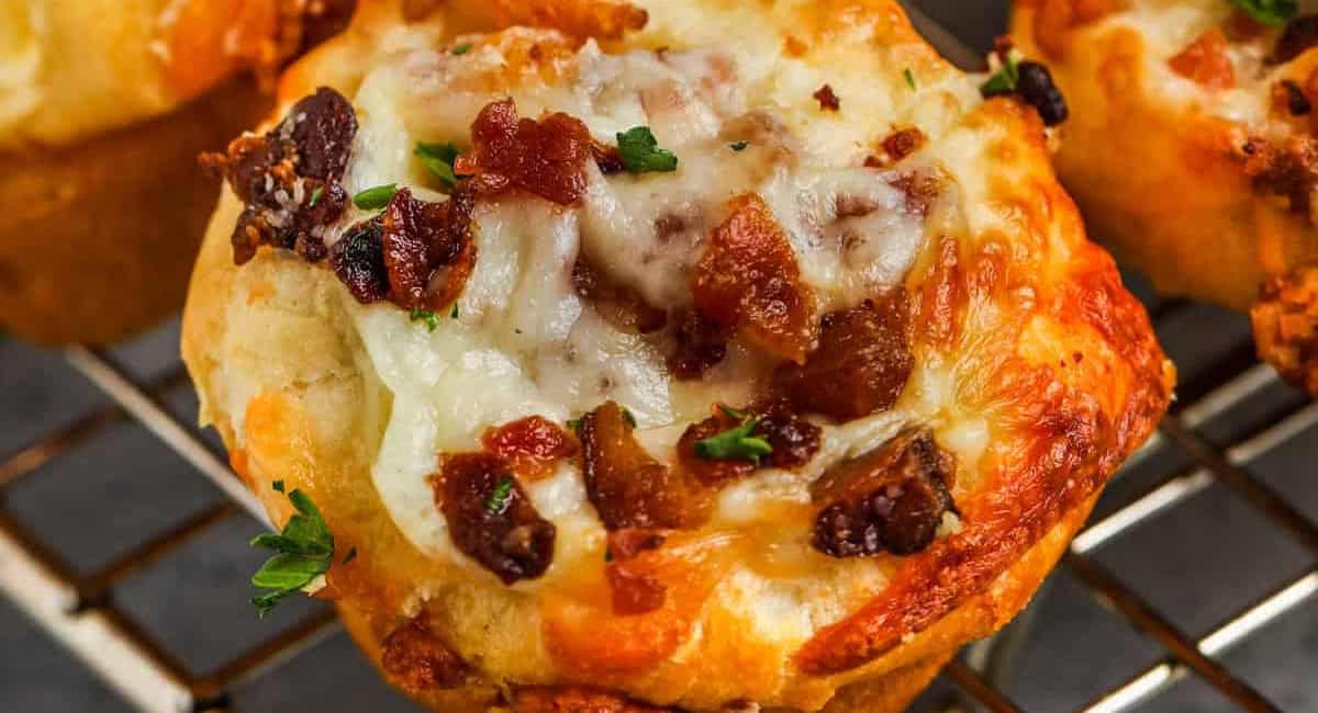 Up close overhead image of bacon and cheese biscuits with garnish. 
