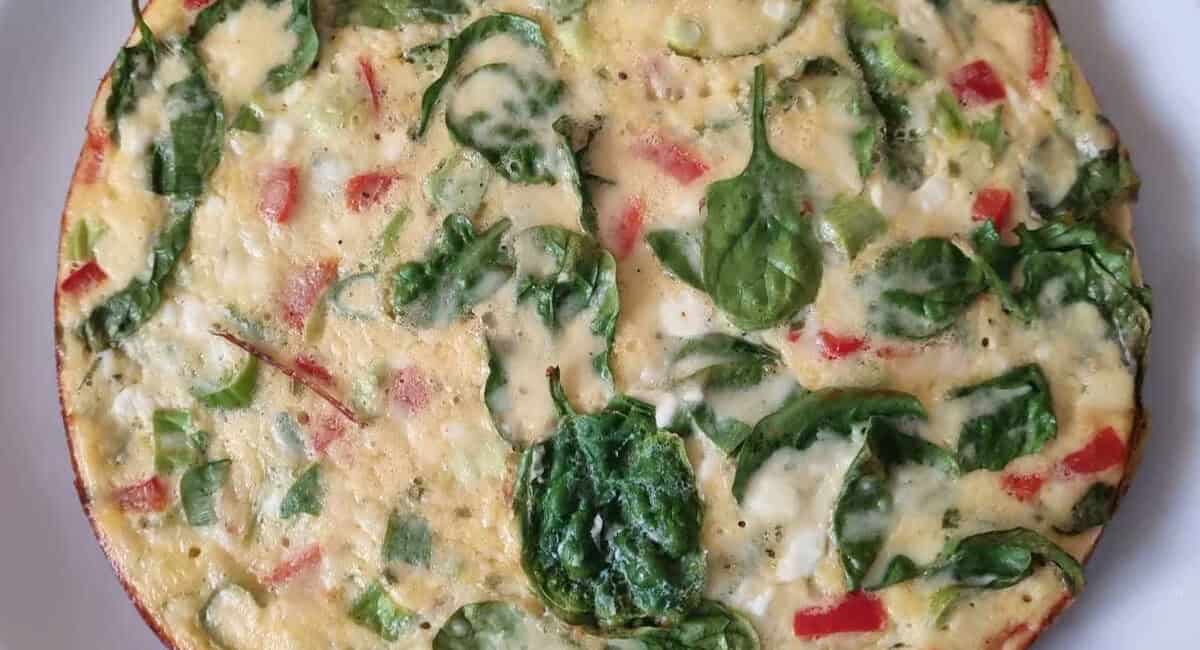 Overhead image of crustless cottage cheese quiche on white dish. 