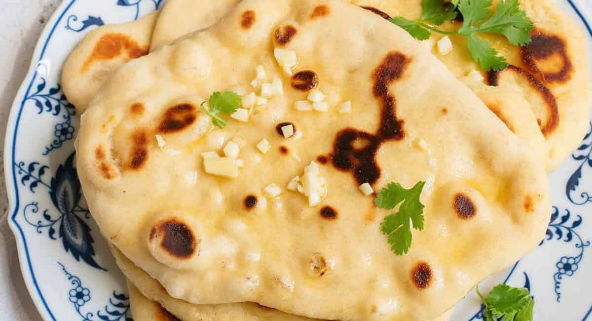 Overhead image of homemade naan with garnish. 
