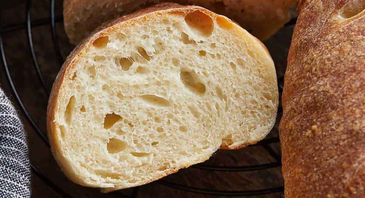 Overhead image of homemade french bread recipe on black wire rack. 