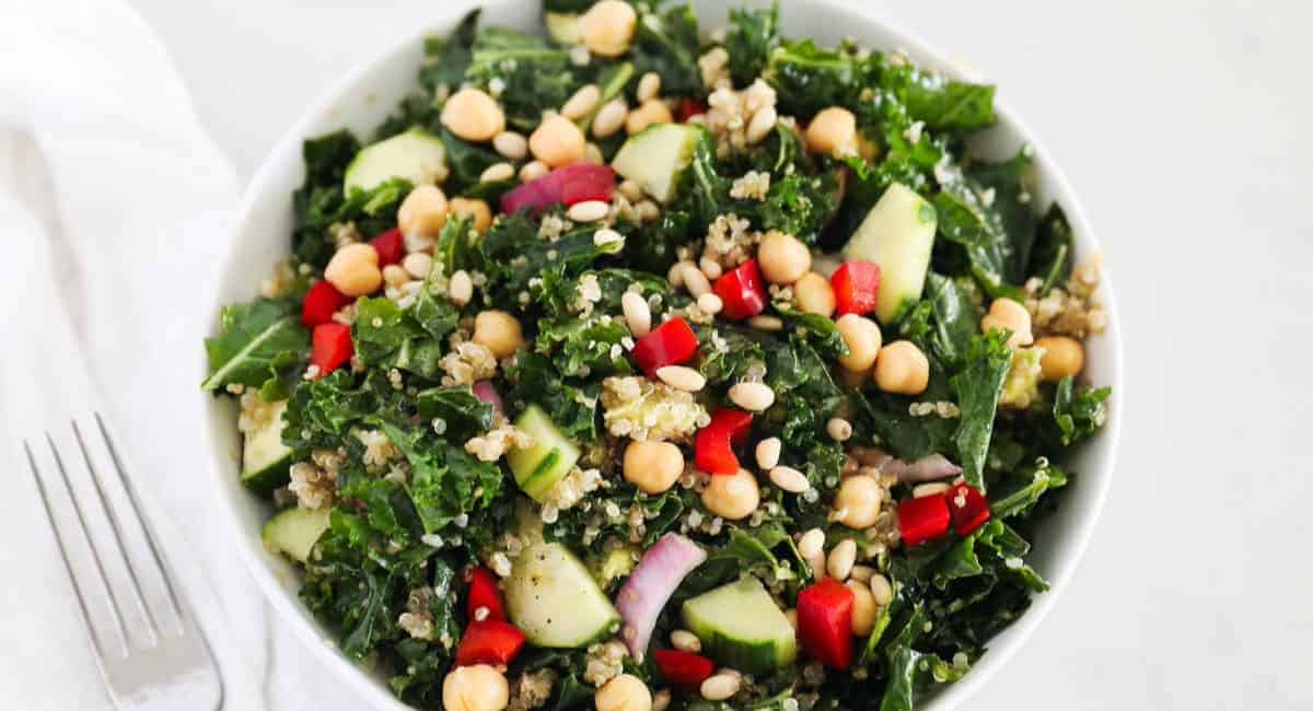 Overhead image of kale quinoa salad in white bowl. 